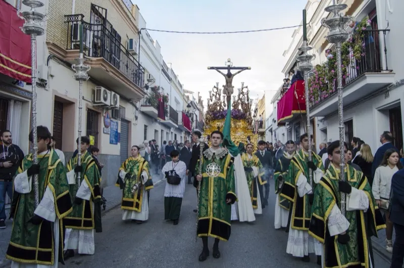 Cuerpo de acólitos con dalmáticas verdes delante del paso de Cristo